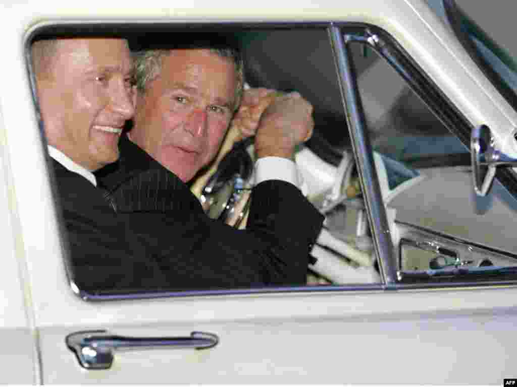 U.S. President George W. Bush leans over the steering wheel while driving Russian President Vladimir Putin&#39;s 1956 Volga outside Moscow in May 2005.