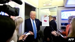 U.S. President Donald Trump speaks with journalists on Air Force One en route from Florida to the White House on February 19. 