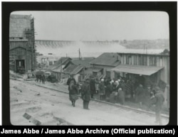 Although Abbe was aware that "photographing any queue is taboo, especially a food queue," he managed to capture these workers in 1932 as they waited outside a food distribution center before it opened for the day. The Dnieper hydroelectric dam can be seen in the background.