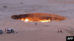 Tourists visit the Gates of Hell, a huge burning gas crater in the heart of the Karakum desert. 