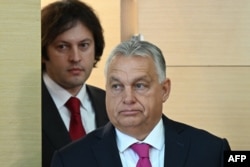 Georgian Prime Minister Irakli Kobakhidze (left) and visiting Hungarian Prime Minister Viktor Orban arrive for a joint briefing in Tbilisi on October 29.