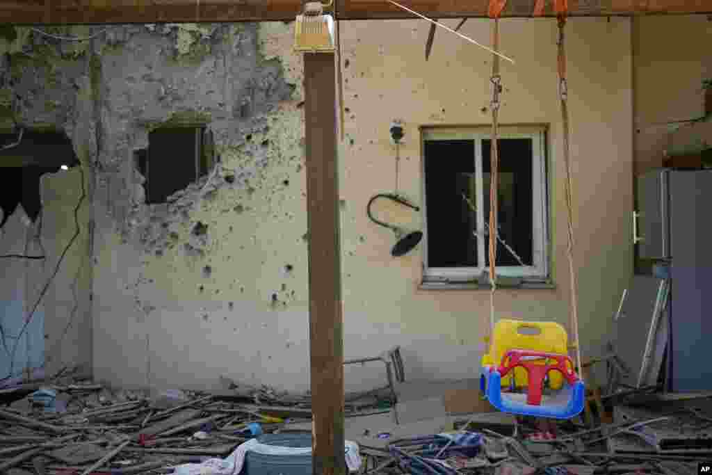 A children&#39;s swing hangs in a house damaged by Hamas militants at the Kibbutz Be&#39;eri, Israel, days after the attack.