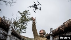 A Ukrainian serviceman launches a combat drone from his frontline position near the town of Pokrovsk in October. 