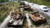 Cars pass by destroyed Russian armored vehicles outside Kyiv late last month. Although the Kremlin has failed in its initial bid to take his country's capital, Ukrainian lawmaker and special forces commander Roman Kostenko believes Moscow hasn't abandoned its ambitions to take the city. 