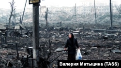 A woman picks her way through the rubble in Grozny during the Second Chechen War in February 2000. 