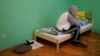 A man who fled persecution in Chechnya due to his sexual orientation sits on his bed in Moscow.