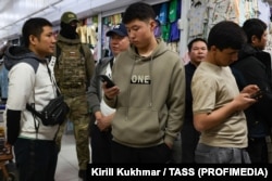 Migrant workers wait during a raid in Novosibirsk.