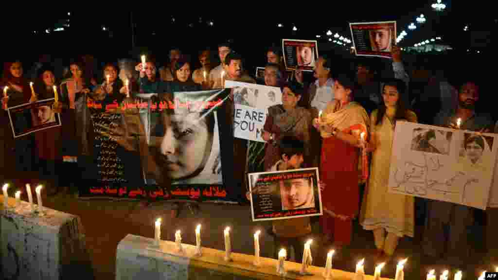 Civil society activists and journalists carry candles and photographs of Yousafzai during a protest against the Taliban&#39;s attempt on her life in Islamabad on October 11, 2012.