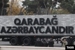 The slogan on this truck reads "Karabakh is Azerbaijan." Under the cease-fire terms, a chunk of the territory has remained under the control of ethnic Armenian forces, including the biggest city, Stepanakert. Nagorno-Karabakh is internationally recognized as part of Azerbaijan, but the ethnic Armenians who make up most of the region's population reject Azerbaijani rule. The backdrop to the slogan is made up of license plates from military vehicles seized by the Azerbaijani Army in the recent conflict, seemingly a pointed reference to a notorious wall constructed from the license plates of vehicles belonging to Azeris who were expelled from Armenia when the first Nagorno-Karabakh war erupted in 1988.