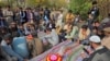 People mourn over the graves of relatives who were killed in fresh sectarian violence in Kurram on November 22. 