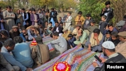 People mourn over the graves of relatives who were killed in fresh sectarian violence in Kurram on November 22. 