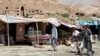 Market stalls in Bamiyan stand in front of one of the niches where the region's famed carved Buddhas, which were blown up by the Taliban in 2001, once stood.