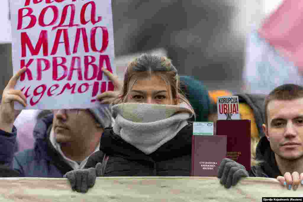 Students hold report cards during a protest demanding action from the state prosecutor in the case of the deaths in the Novi Sad railway station disaster in November, in Belgrade.